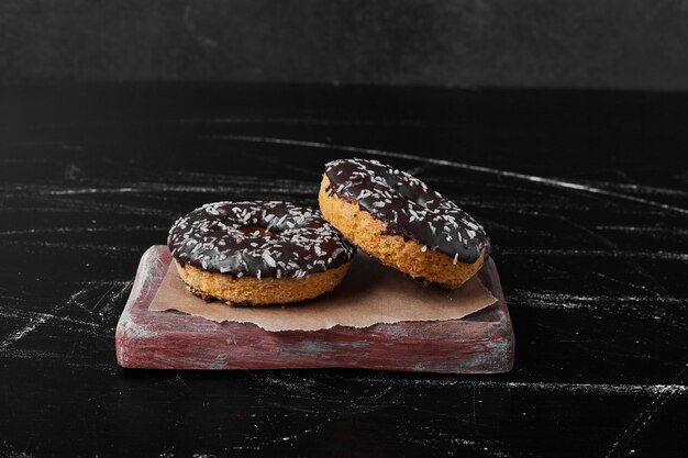 Chocolate doughnuts on the wooden board.