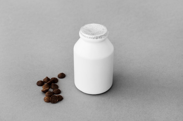Chocolate drops near bottle of dairy