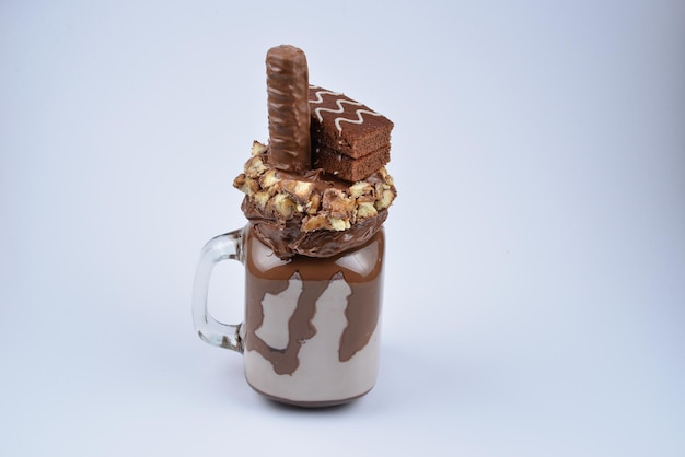 Шоколадный экстремальный молочный коктейль с шоколадным пирогом, шоколадной пастой и конфетами. безумный фуршетный тренд. копировать пространство