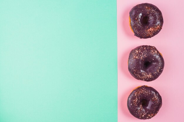 Chocolate frosted brown doughnuts decorated with sprinkles