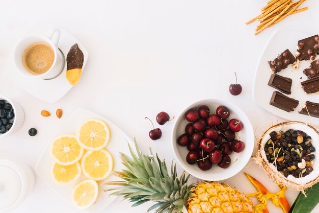 Chocolate; fruits and coffee with bread on white backdrop