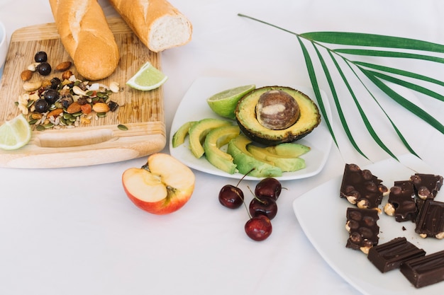 Chocolate; fruits and dryfruits with bread on white backdrop