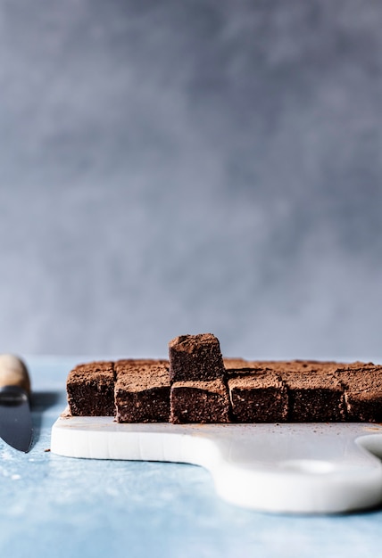 Chocolate ganache truffle squares dusted with cacao on a cutting board