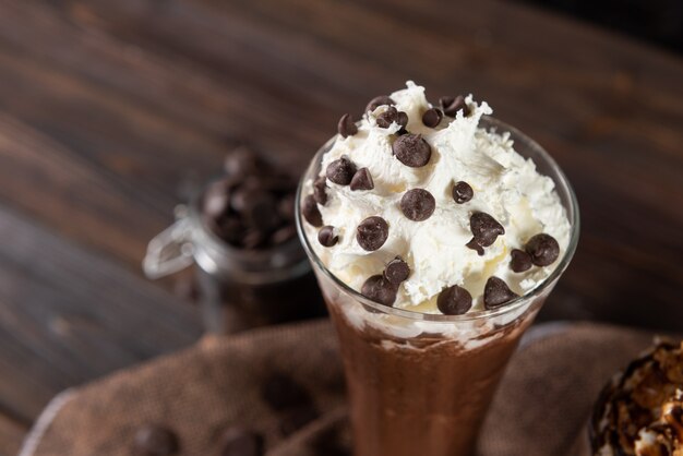 Шоколадный молочный коктейль со взбитыми сливками и шоколадной стружкой