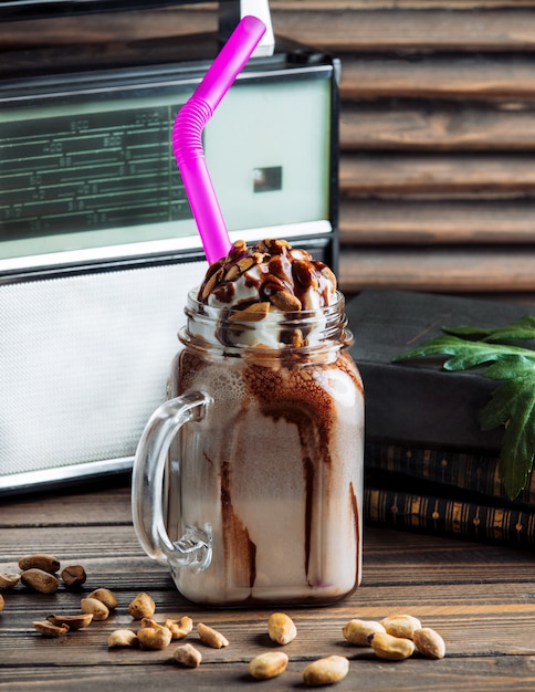 Chocolate milky shake with whipping cream in a glass jar.