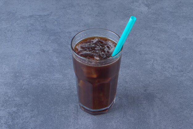 Chocolate mocha in a glass with straw, on the blue table.