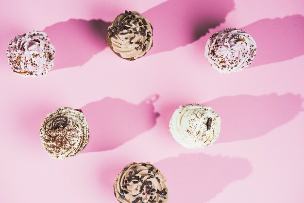 chocolate muffins filled with sweet cream over pink background