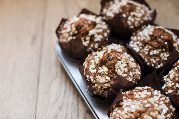 Chocolate muffins in paper cupcake holder on wooden backdrop