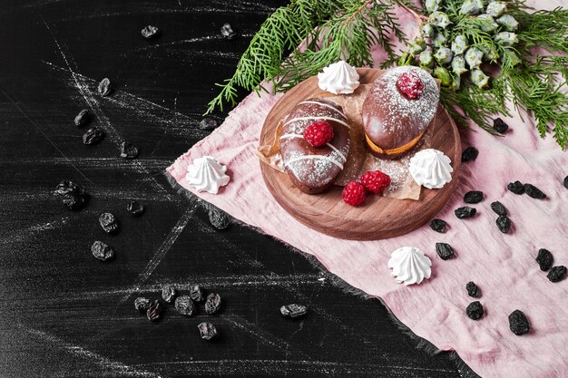 Chocolate muffins on wooden platter .