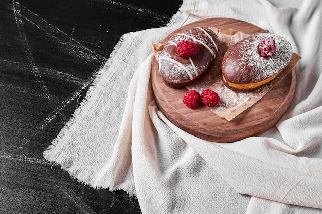 Chocolate muffins on wooden platter .