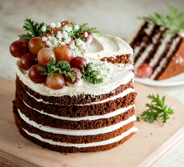 Chocolate naked cake decorated with white cream grapes and baby's-breath flowers