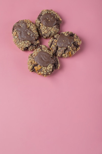 Chocolate nuts cookies on a pink table .