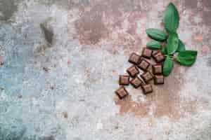 Бесплатное фото Шоколадные кусочки с листьями на деревенском фоне гранж