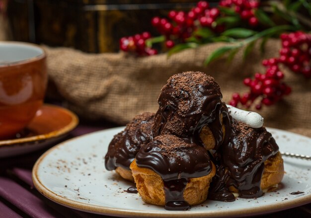 Chocolate profiteroles with cocoa on the top .
