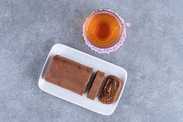 Torta al cioccolato e tazza di tè sulla superficie di marmo