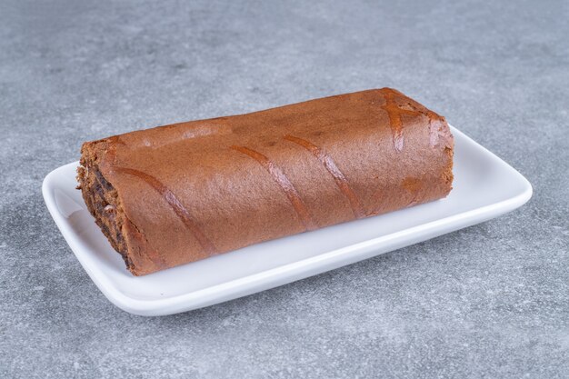 Chocolate roll cake on white plate