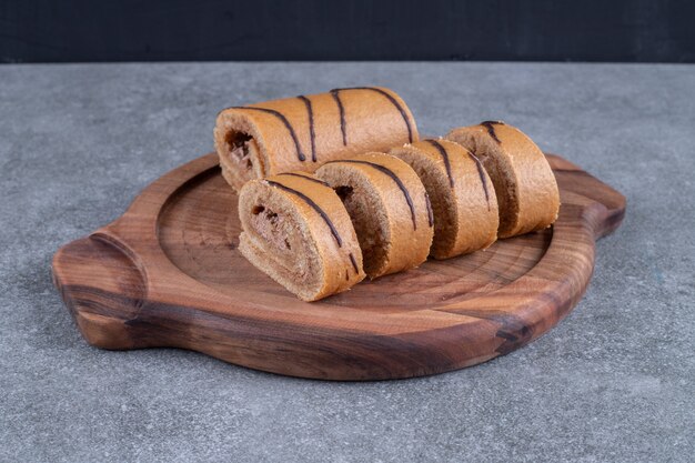 Chocolate roll cake on wooden plate