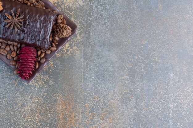 Free photo chocolate roll with coffee beans and pinecones. high quality photo