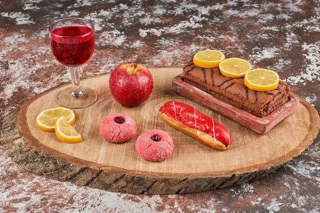 Chocolate rollcake with cookies on a wooden board.