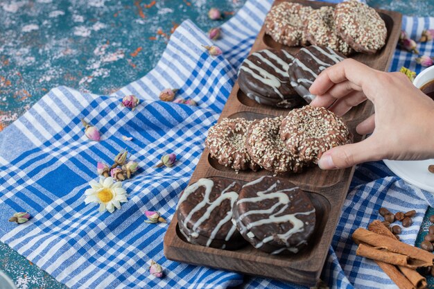 Chocolate and sesame cookies on a wooden board.