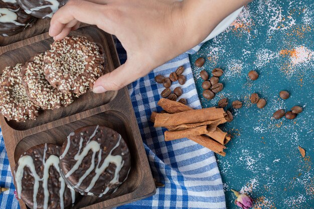 Chocolate and sesame cookies on wooden platter.