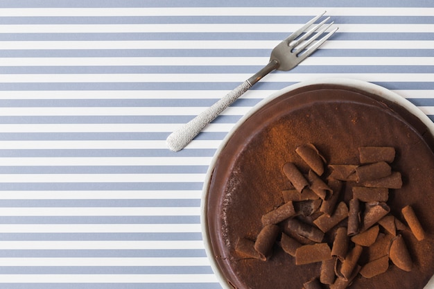 Chocolate shreds toppings on baked cake over the stripes background