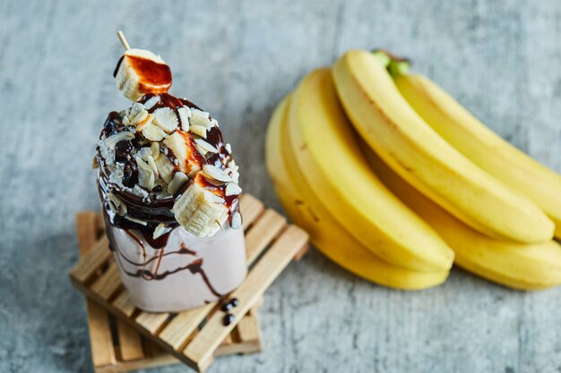 Chocolate smoothie with choco syrup and branch of bananas 