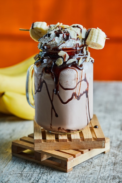 Chocolate smoothie with choco syrup and branch of bananas 