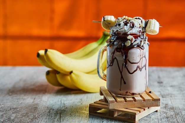 Chocolate smoothie with choco syrup and branch of bananas 