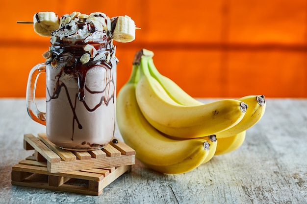 Chocolate smoothie with choco syrup and branch of bananas 