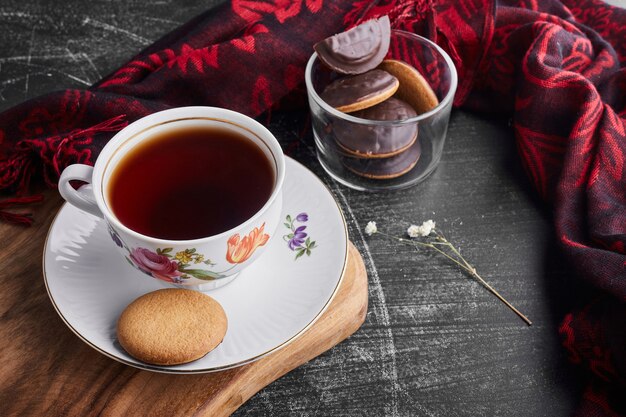 お茶とガラスのカップにチョコレートスポンジクッキー。