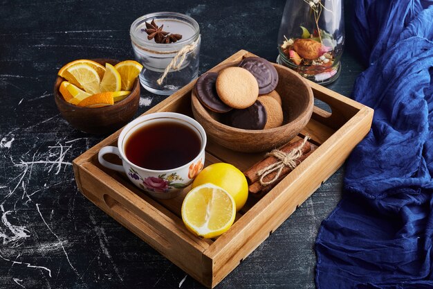 Chocolate sponge cookies with a cup of tea and lemon. 