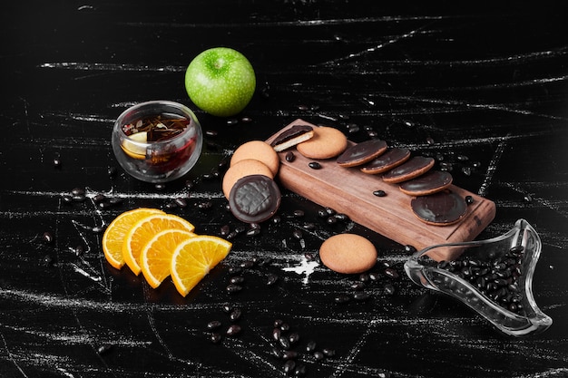 Free photo chocolate sponge cookies on a wooden board with herbal tea.