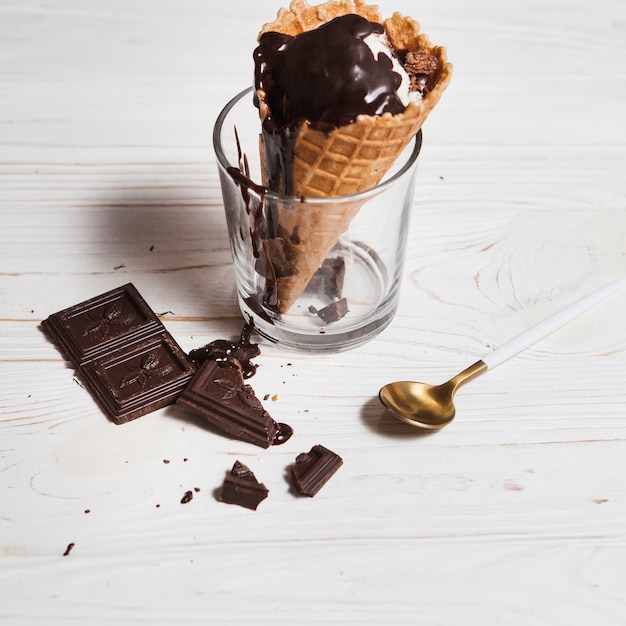 Chocolate and spoon near cup and ice-cream