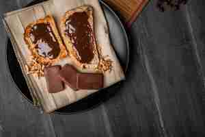 Foto gratuita cioccolato spalmato su pane tostato piatto laico