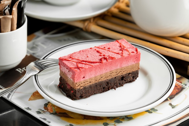 Chocolate and strawberry cheesecake plate garnished with strawberry syrup