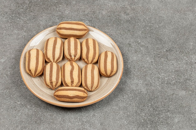 Шоколадное полосатое печенье на керамической тарелке
