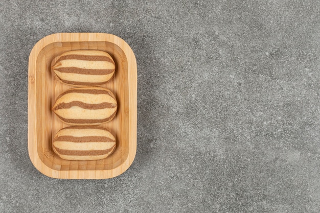 Chocolate striped biscuits on wooden plate