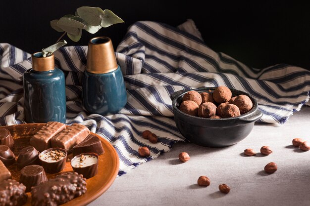 Chocolate sweets on plate and chocolate truffles in bowl