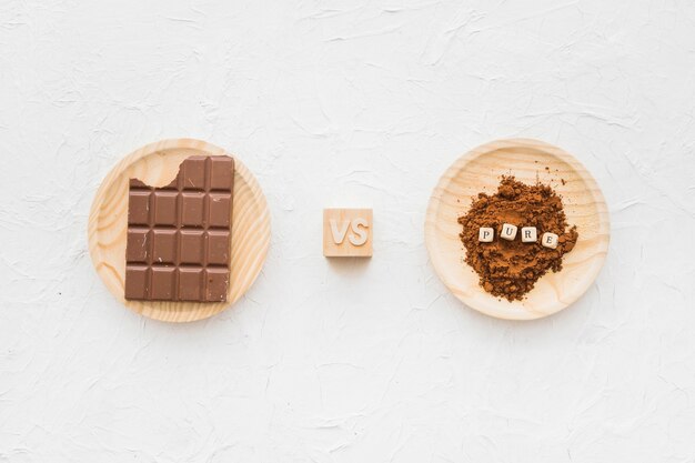 Free photo chocolate versus cocoa powder with pure cubic blocks