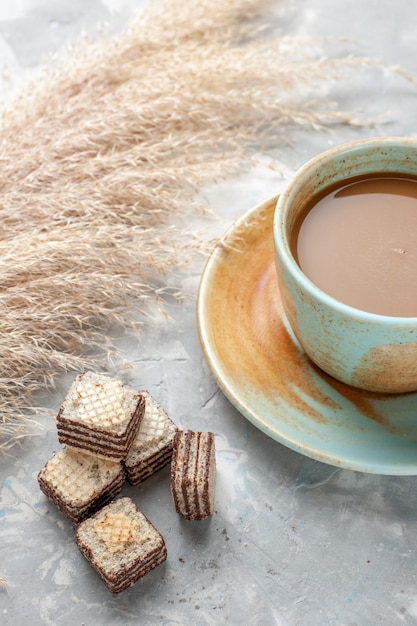Foto gratuita cialde al cioccolato con caffè al latte su grigio-bianco