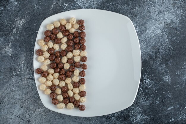 Chocolate and wheat balls on white plate.