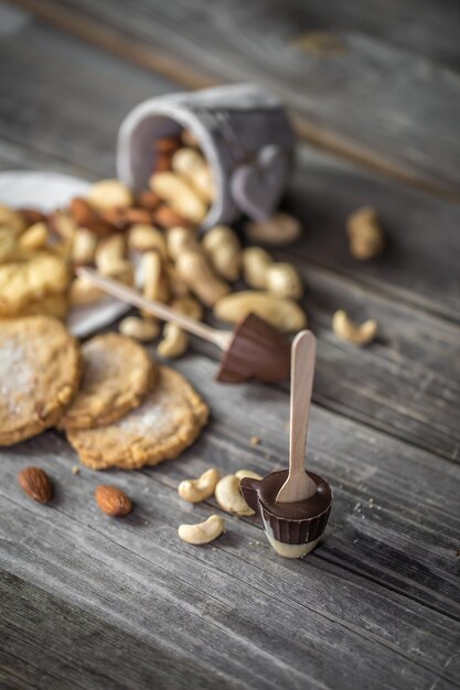 木製の表面にチョコレート、クッキー、ナッツ