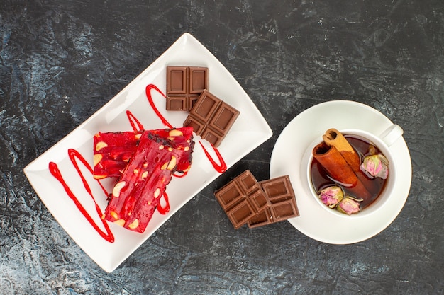 chocolates on white plate and a cup of herbal tea on grey