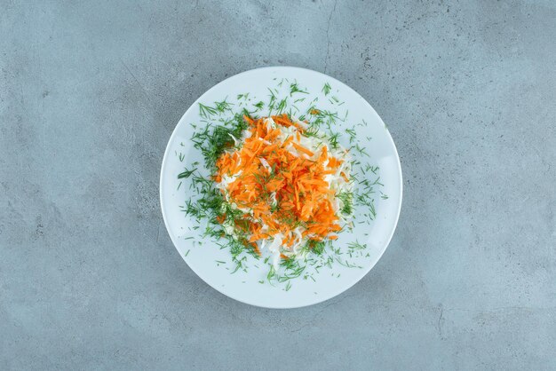 Chopped cabbage and carrots on white plate.