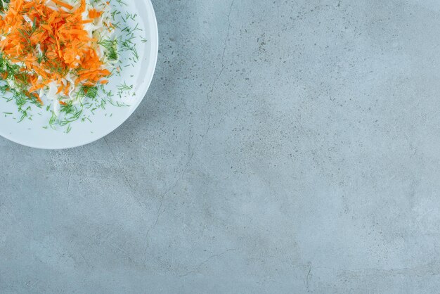 白い皿に刻んだキャベツとにんじん。