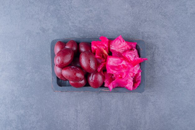 Chopped cabbage and palm on grey wooden plate . Top view.