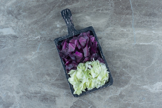 Free photo chopped cabbage in the wooden board , on the marble table.