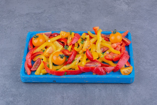 Chopped colorful bell pepper salad in a wooden platter