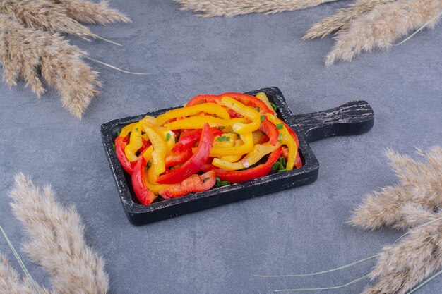 Chopped colorful bell pepper salad in a wooden platter